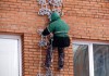 Фото Новогоднее украшение фасада зданий альпинистами